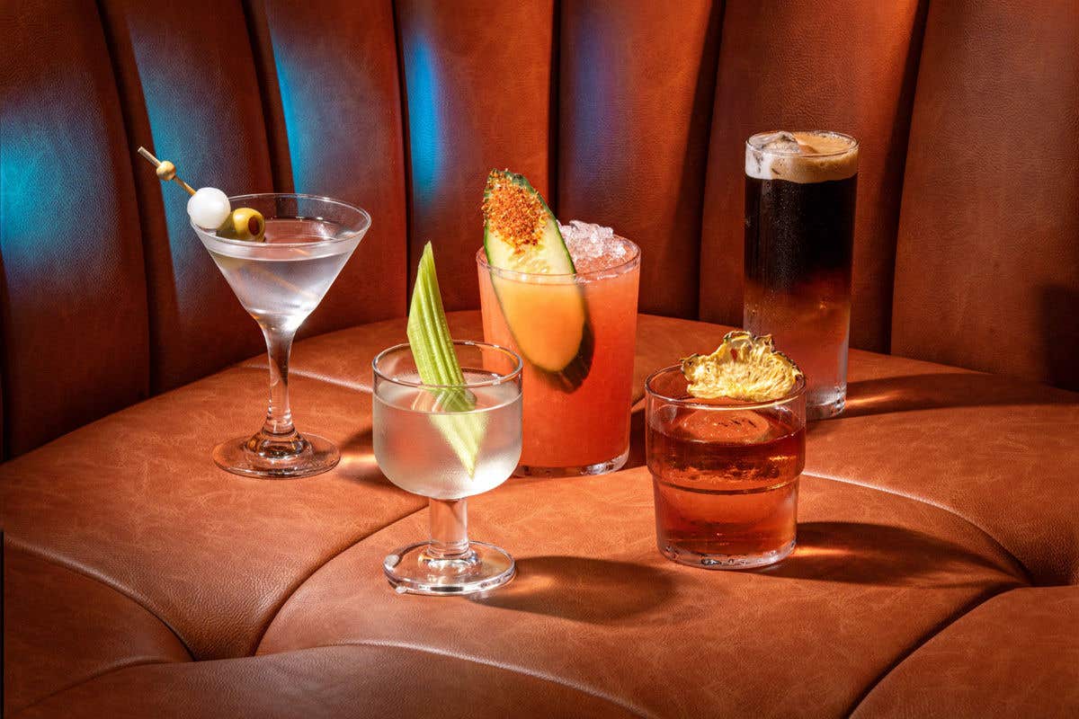 Assortment of drinks on a brown tufted leather seat backdrop. 