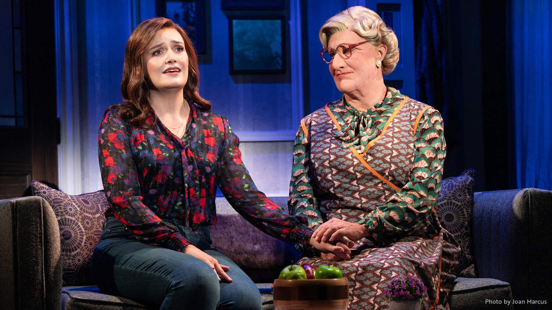 Mrs. Doubtfire comforting the mom while seated on the couch.