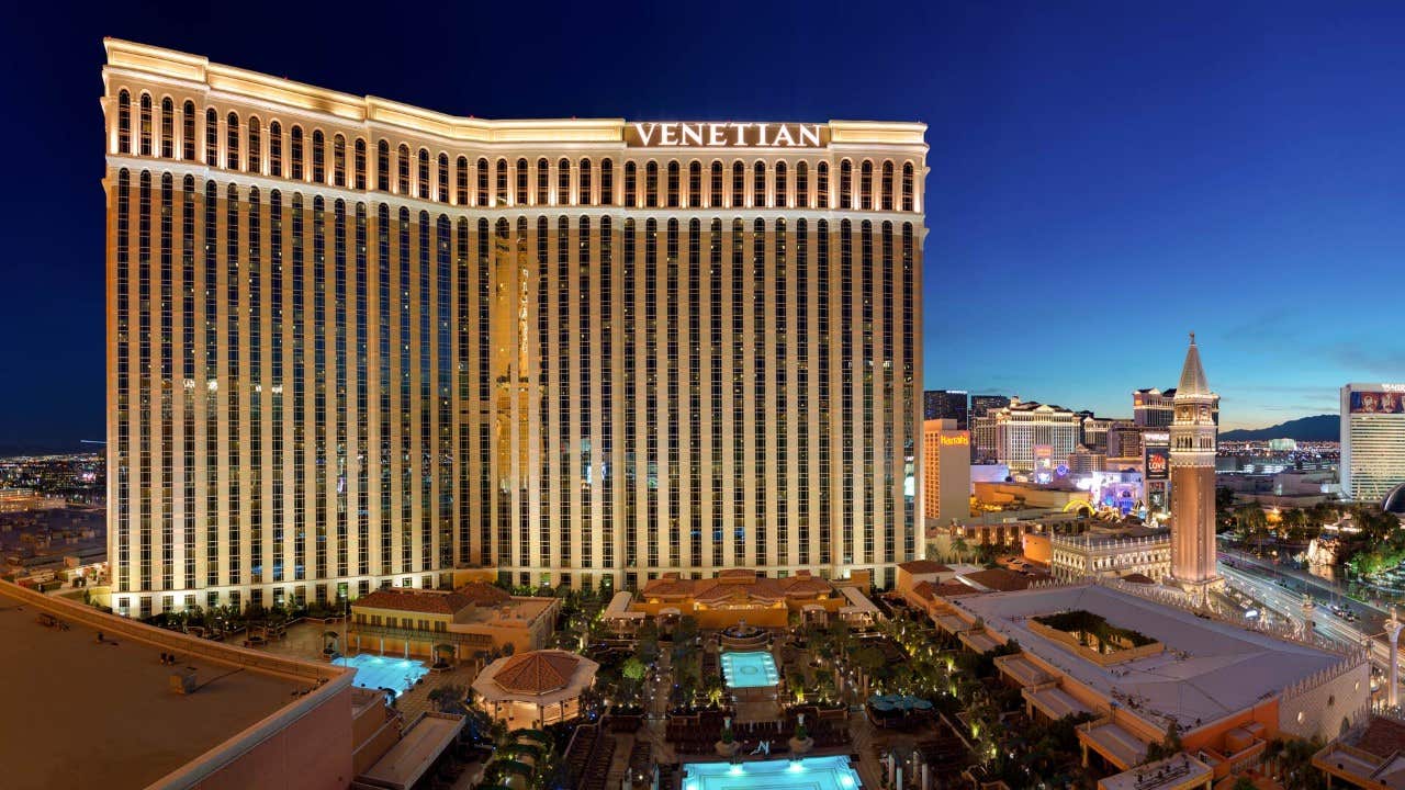 The Venetian Resort in Las Vegas illuminated at night with surrounding cityscape views.