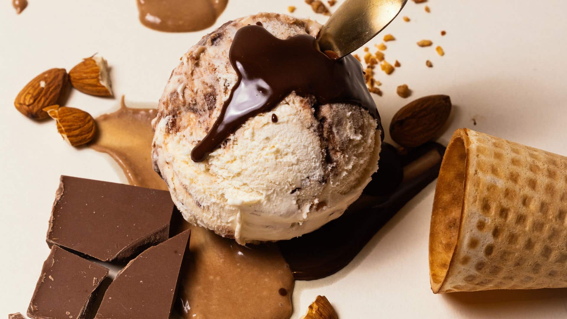 Gelato topped with chocolate sauce, almonds, and chocolate chunks